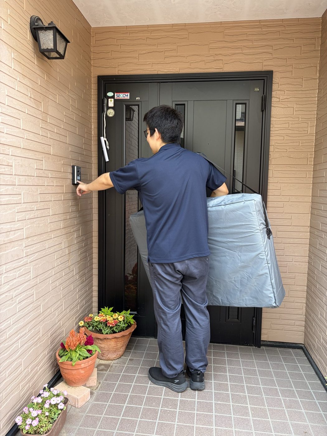 玄関先でインターホンを押す様子